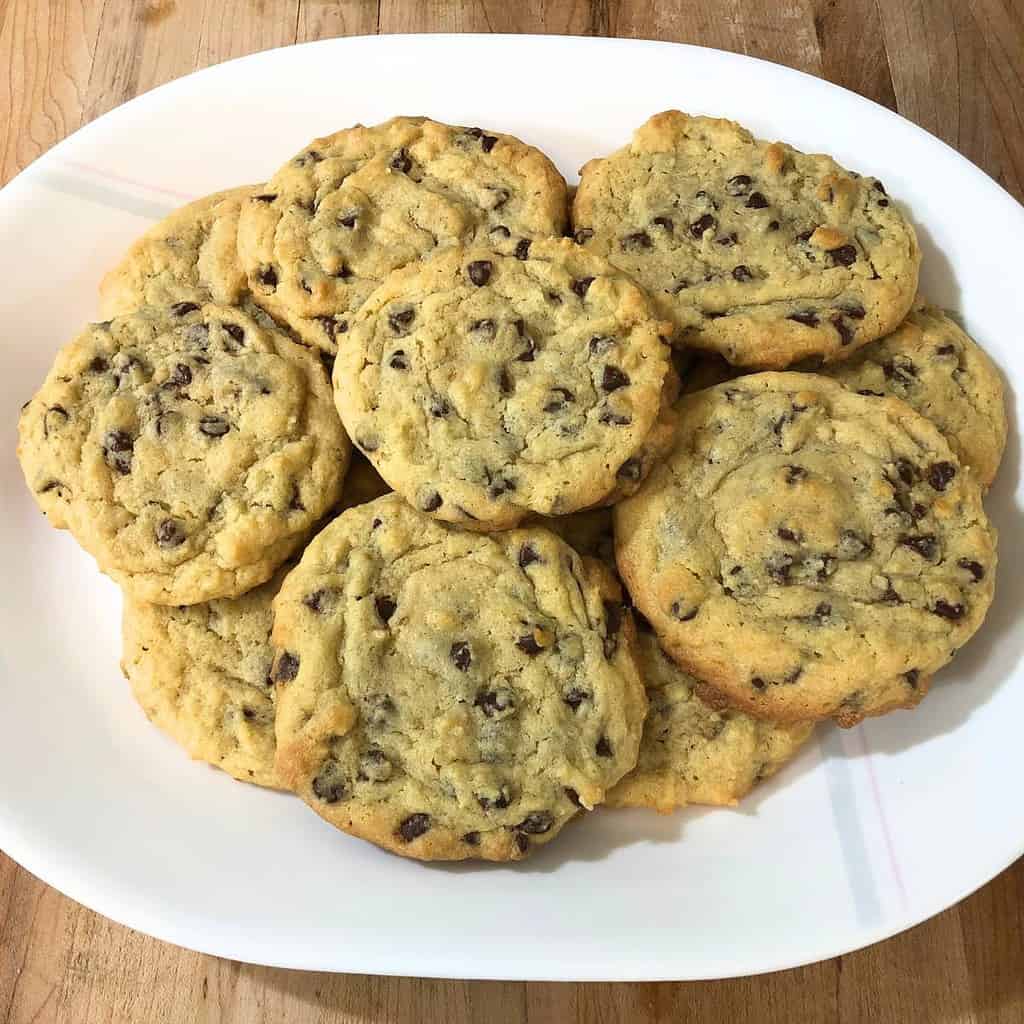 Old-fashioned chocolate chip cookies piled on a white platter.