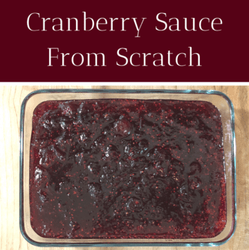 A glass dish with cranberry sauce on a wooden counter.