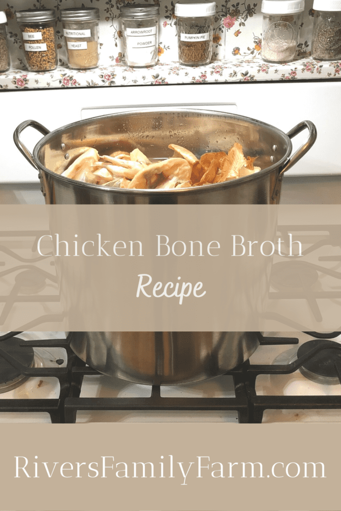 A large stainless steel stockpot on a stove with chicken bones and vegetable scraps inside for making chicken bone broth.