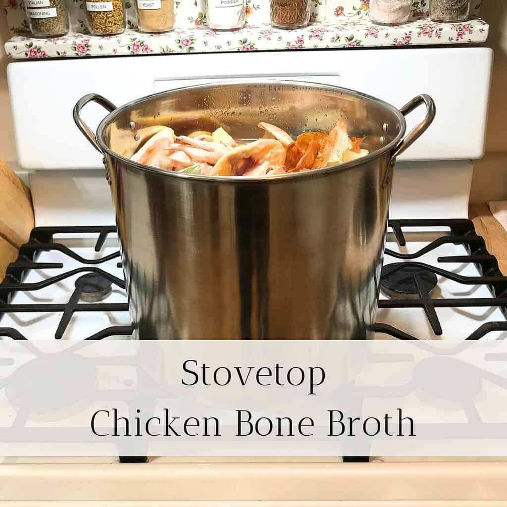 Large stainless steel stockpot on the stove with chicken bones and vegetable scraps for making chicken bone broth. The title is "Stovetop Chicken Bone Broth."
