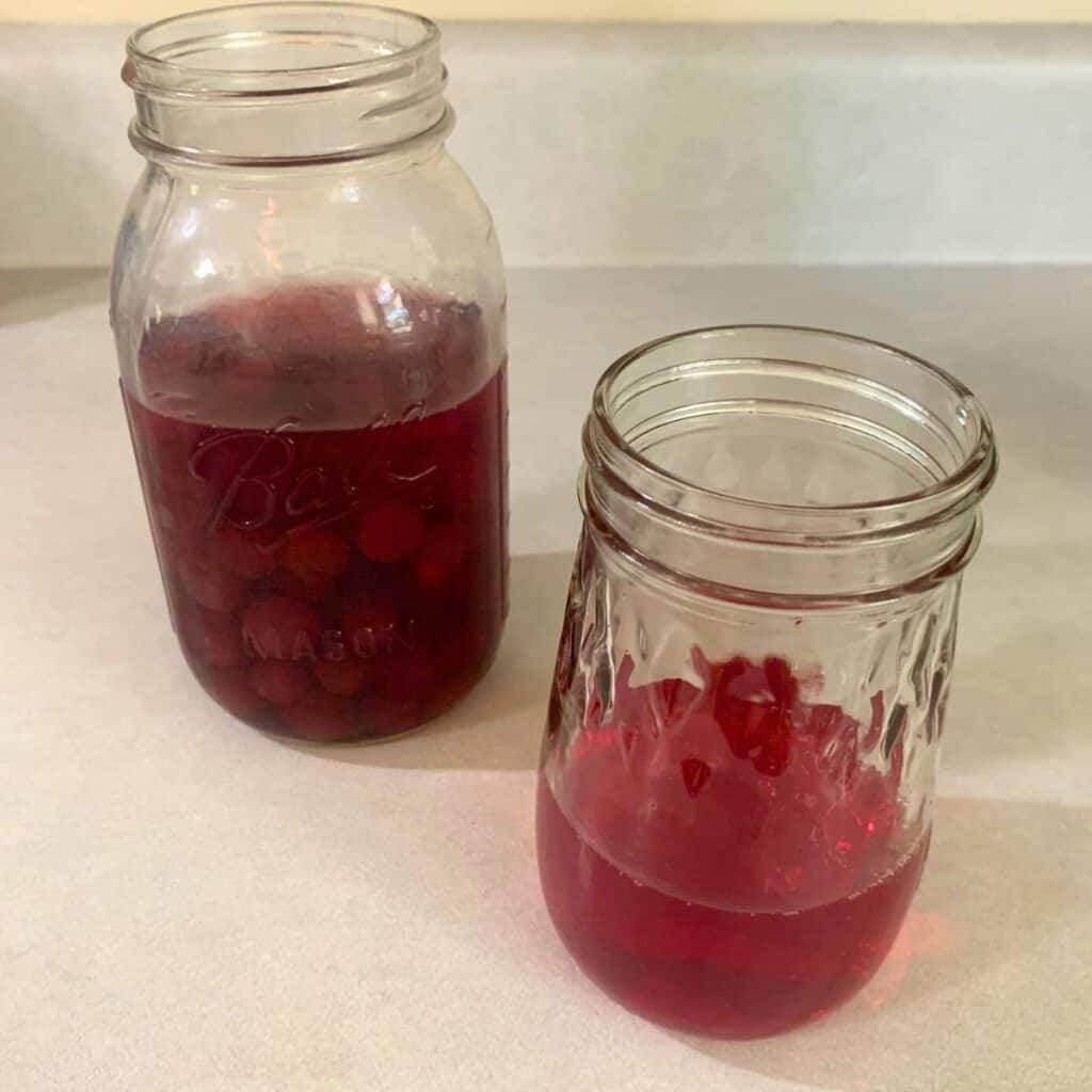 Two glass jars of home canned cranberry juice.