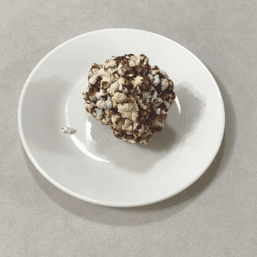 A popcorn ball on a white plate.