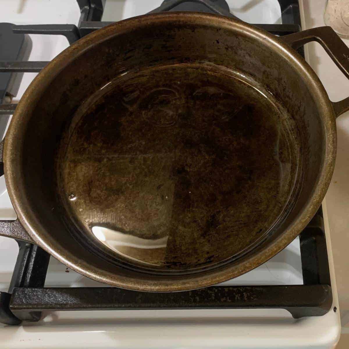 A cast iron skillet sitting on a white gas stove.