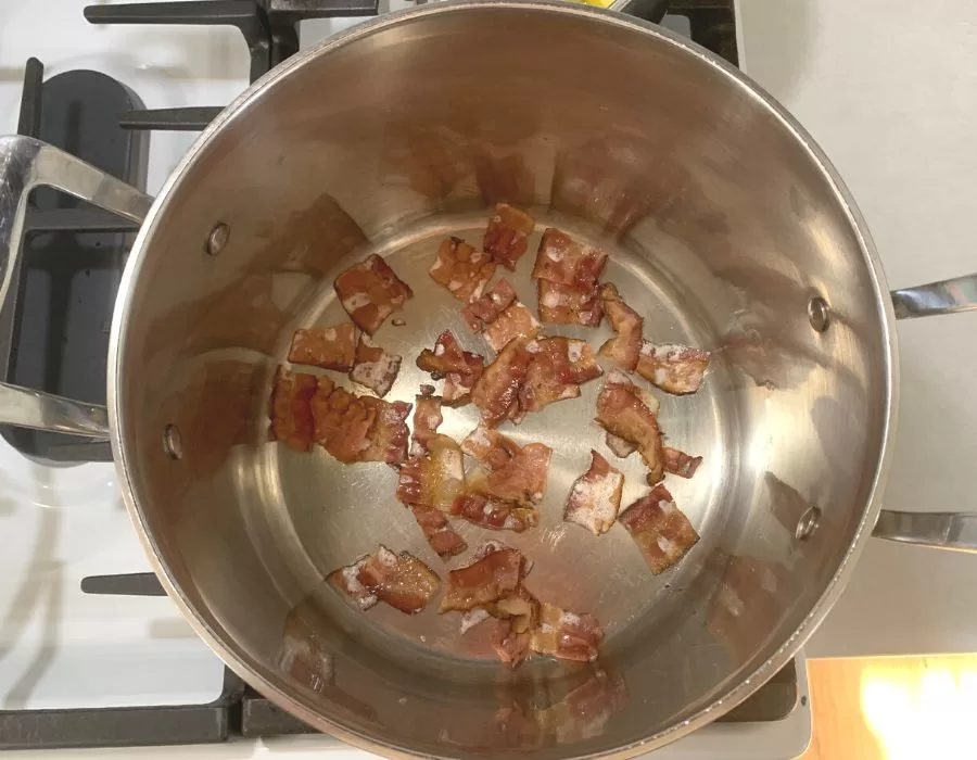 Bacon browning in a pot on the stove. Southern Black Eyed Peas and Collard Greens.