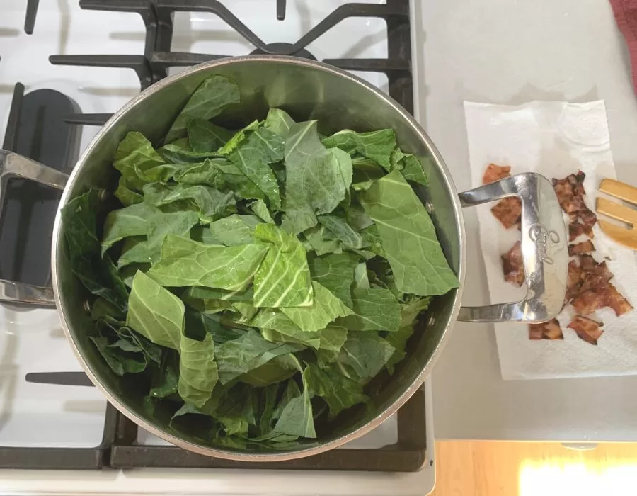 Cooking collard greens in a stainless steel pot. Southern Black Eyed Peas and Collard Greens Recipe.