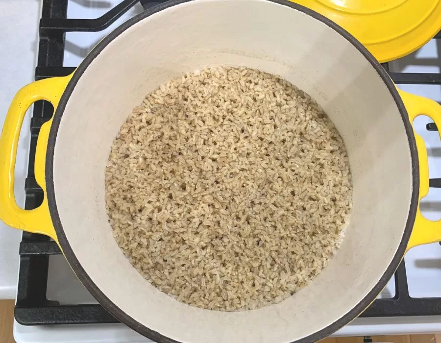 Cooked rice in a yellow dutch oven on the stove.