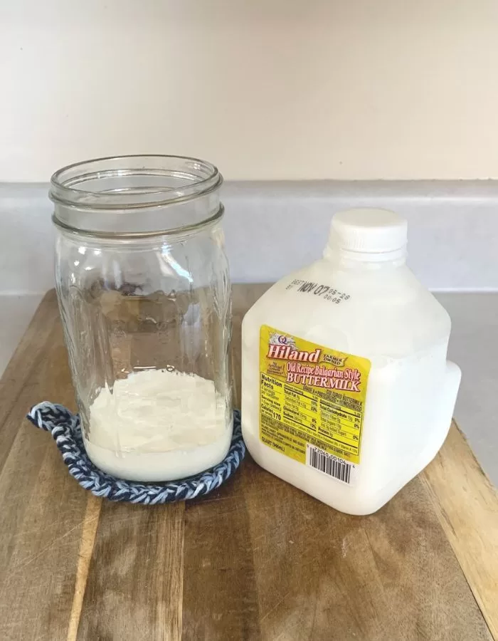 A half cup of buttermilk in a quart mason jar.