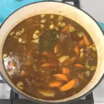 Beef stew in a blue pot on the stove.