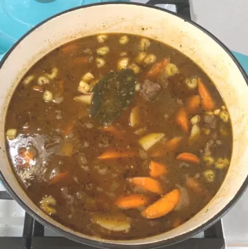 Beef stew in a blue pot on the stove.