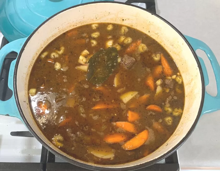 Beef stew in a blue pot on the stove.