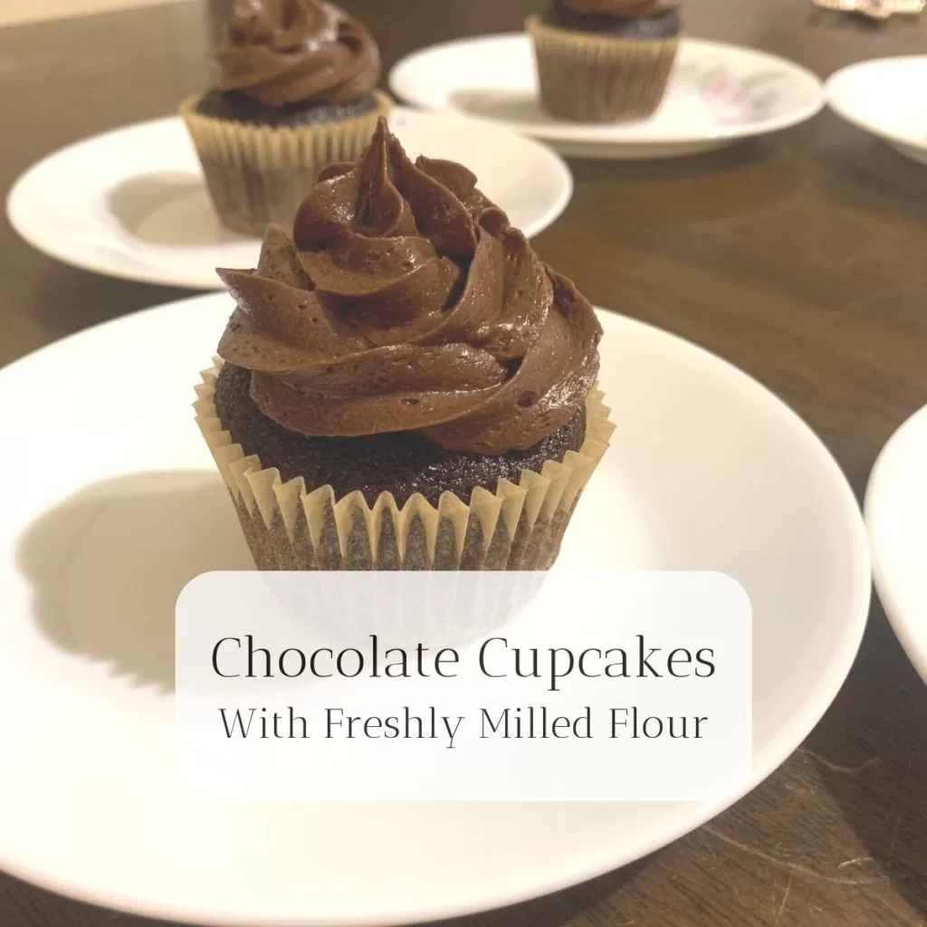 Chocolate cupcakes on a white plate with the title "Chocolate Cupcakes With Freshly Milled Flour."