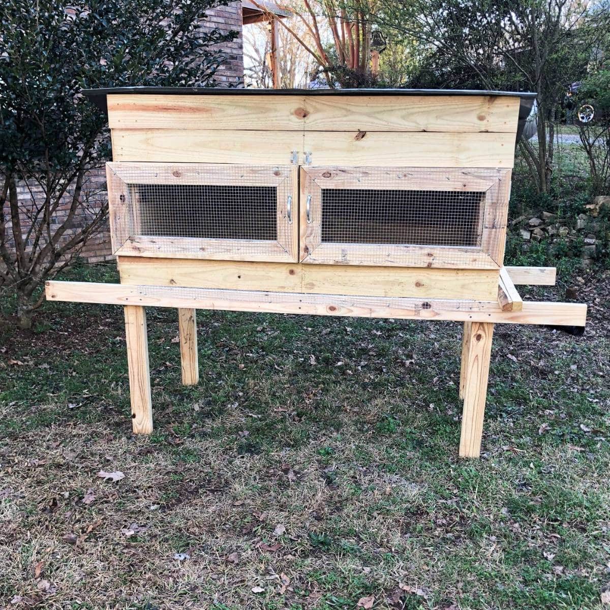 A homemade chicken brooder on grass.