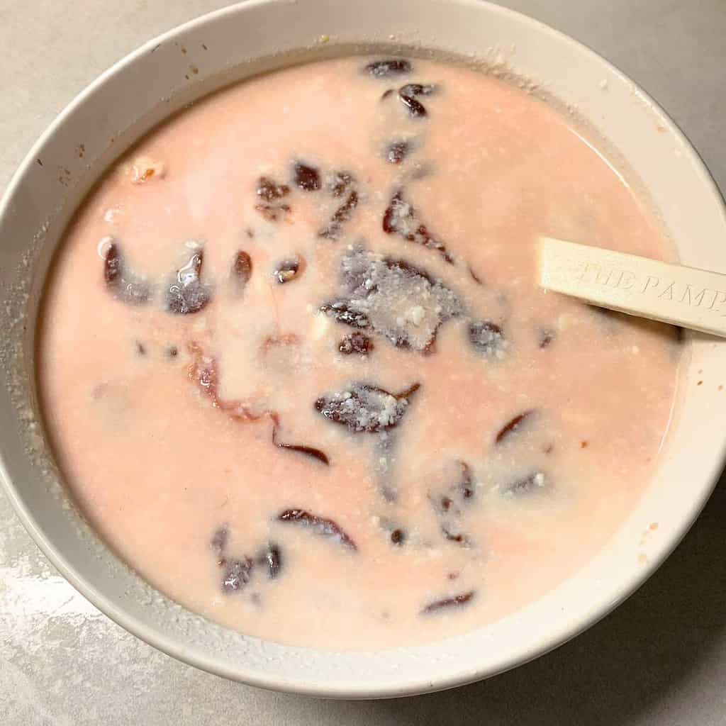 Chicken livers soaking in buttermilk in a large white bowl.