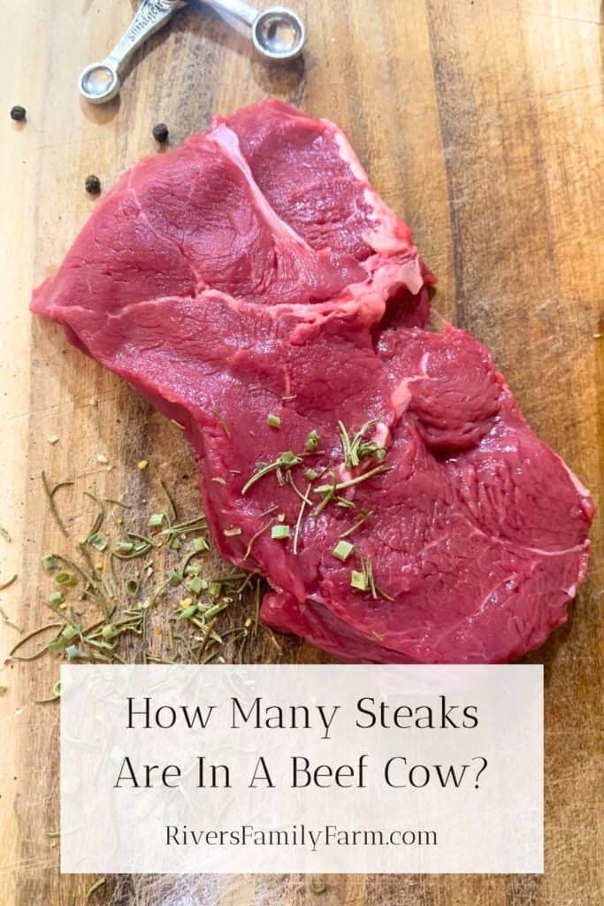A raw, juicy steak on a wooden cutting board with salt and herbs on top. The title is "How Many Steaks Are In A Beef Cow?" by Rivers Family Farm.