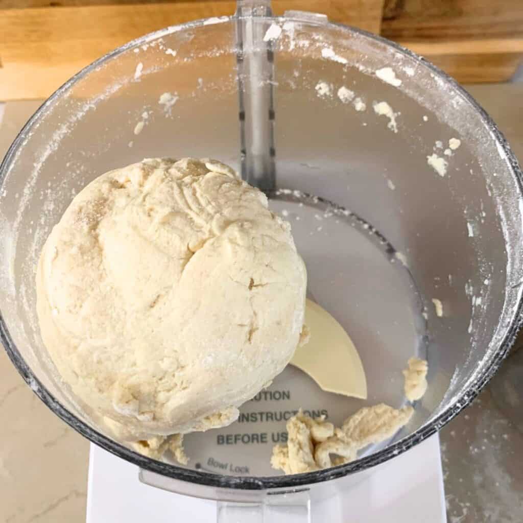A ball of biscuit dough in a food processor.