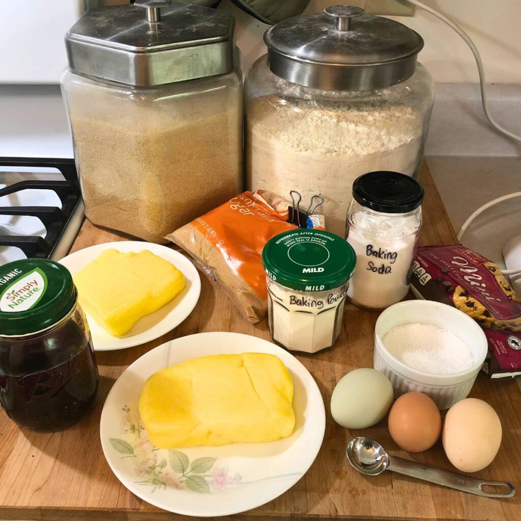 Ingredients for making chocolate chip cookies sitting on a kitchen counter.