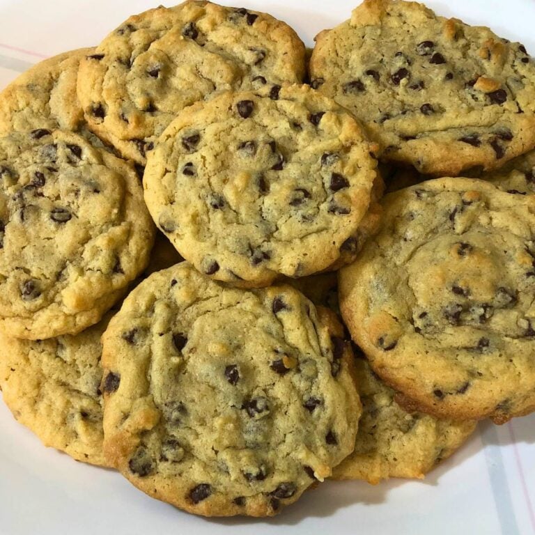 A stack of chocolate chip cookies on a white plate.