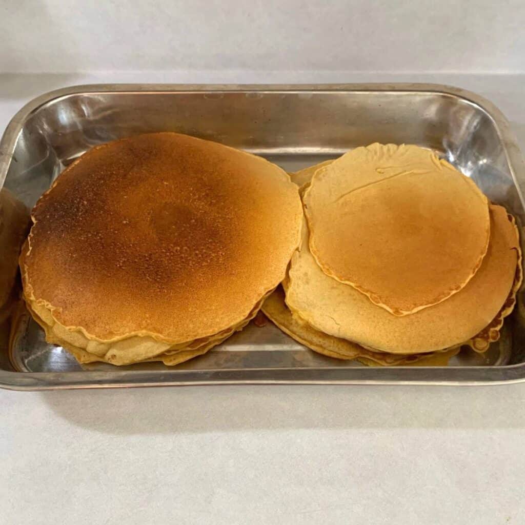 Pancakes in a large stainless steel pan.