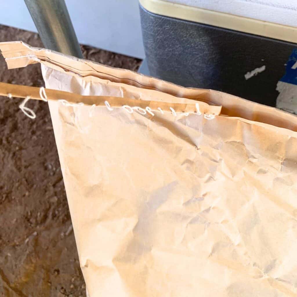 Woman pulling the string off a feed bag so that it opens easily.