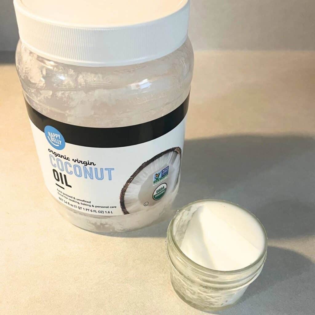 Jars of organic coconut oil sitting on a kitchen counter.