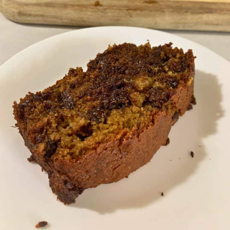 A slice of moist chocolate banana bread on a white plate.