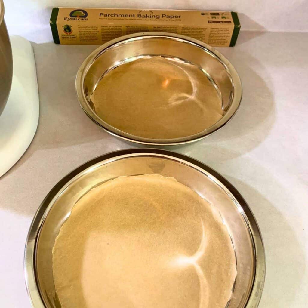 Two round cake pans lined with parchment paper.