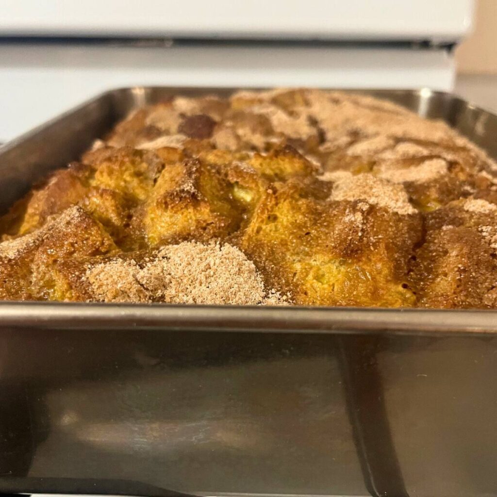 A baked French toast casserole in a stainless steel pan.