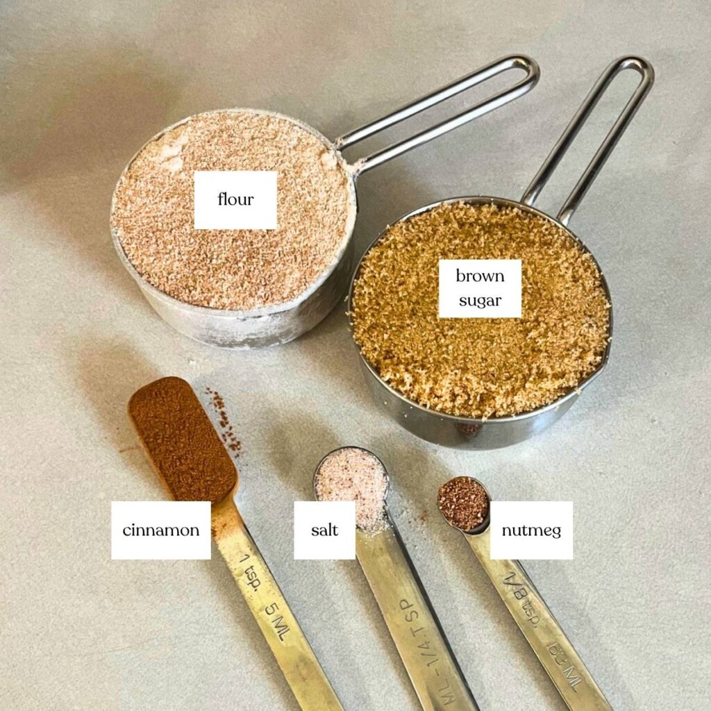 Ingredients to make a sweet topping for French toast casserole. Pictured from left to right and back to front are flour, brown sugar, cinnamon, salt, and nutmeg.